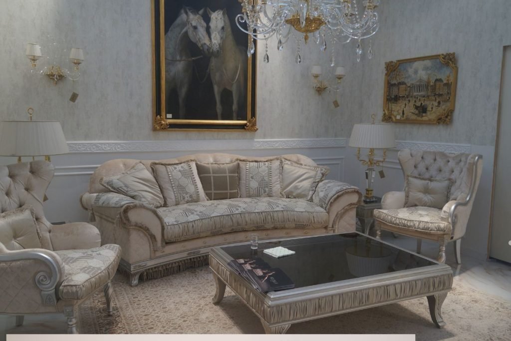 A living room featuring a chandelier, a painting on the wall, and furniture undergoing repair.